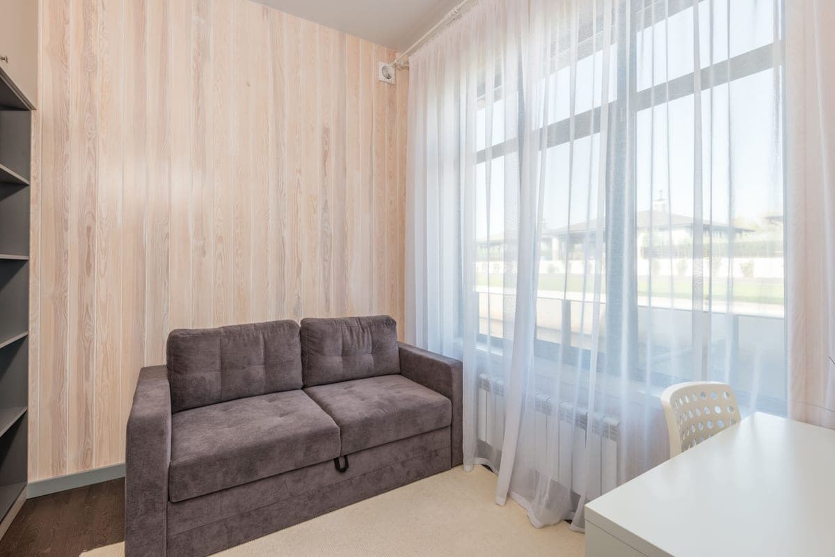A low-profile upholstered sofa in a small, sparsely furnished room