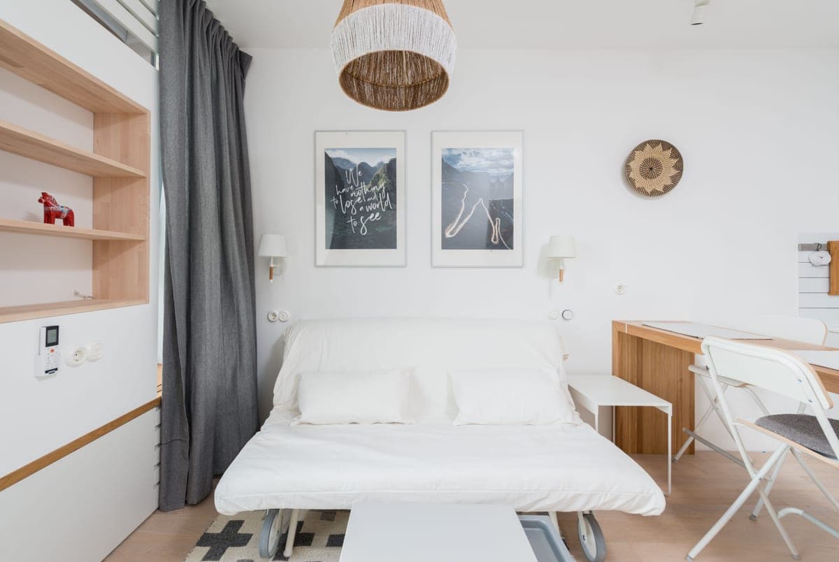 A sofa bed opened out flat as a sleeping surface in a contemporary apartment