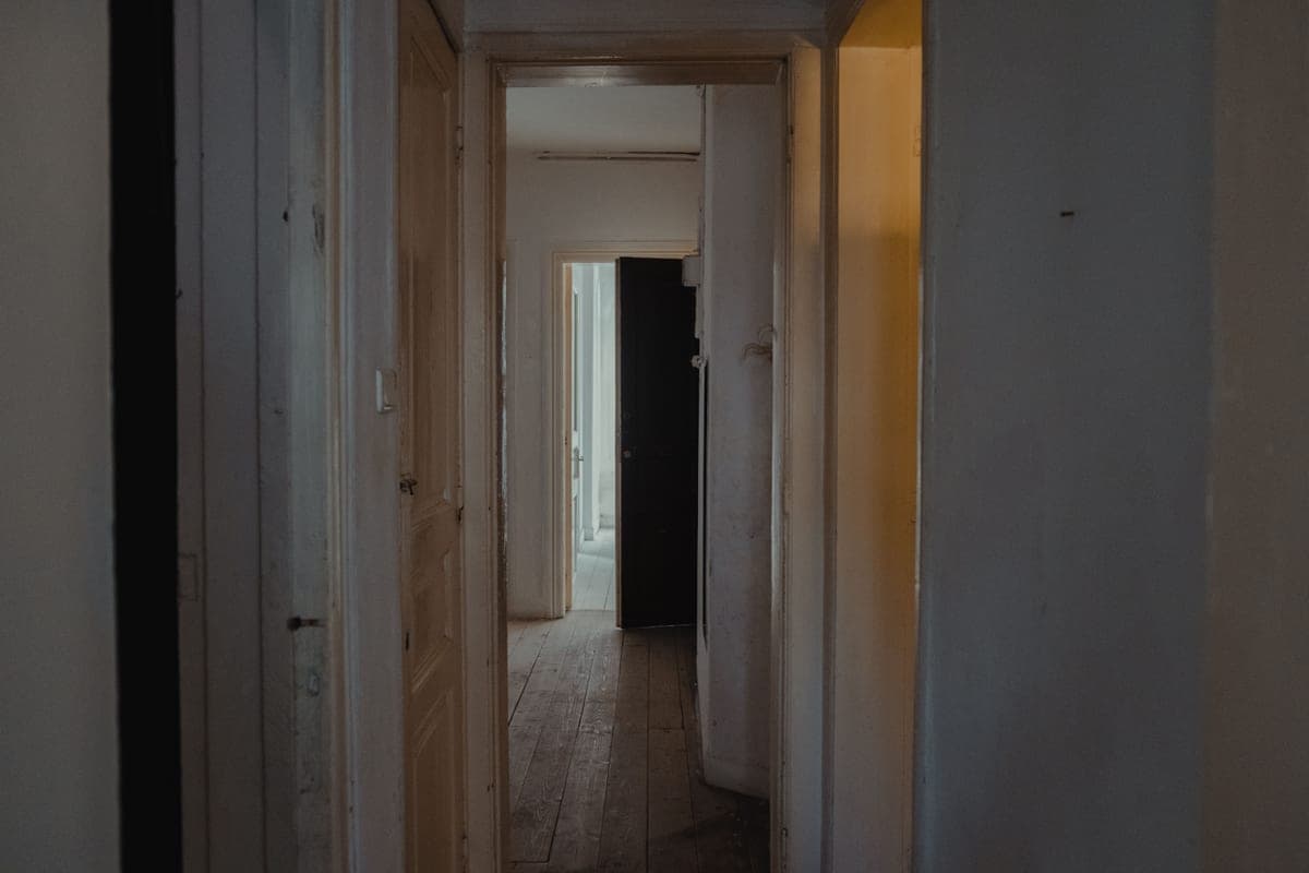 A narrow interior hallway showing a short run of uninterrupted wall